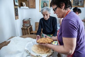 Antoniangela prepara le parti di pane e cozzula de casu per s'imbiatu