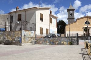 paesaggio campestre con chiesa e figure maschili